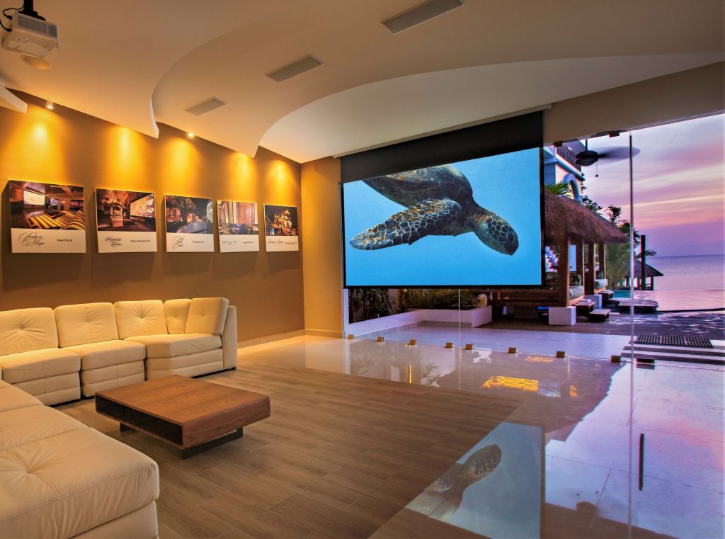 Living Room with Projector Screen and Sunset Ocean View