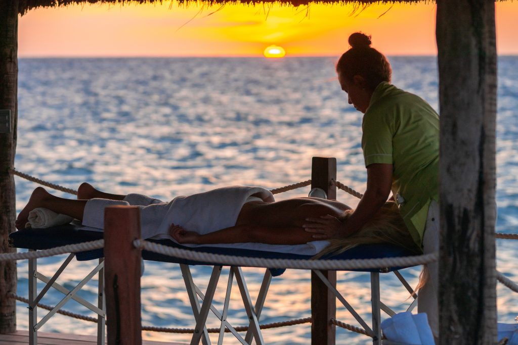 Massage at Private Paradise Cozumel Waterfront Cabana with sun setting over the horizon on the Caribbean ocean 