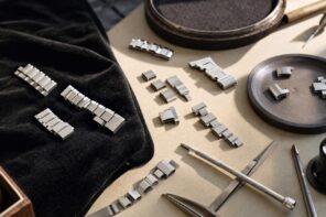 Platinum watch bracelet links and watchmaking tools on a workbench