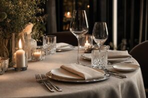 Elegantly set dining table with wine glasses, candles, and flowers