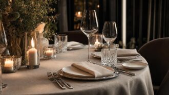 Elegantly set dining table with wine glasses, candles, and flowers