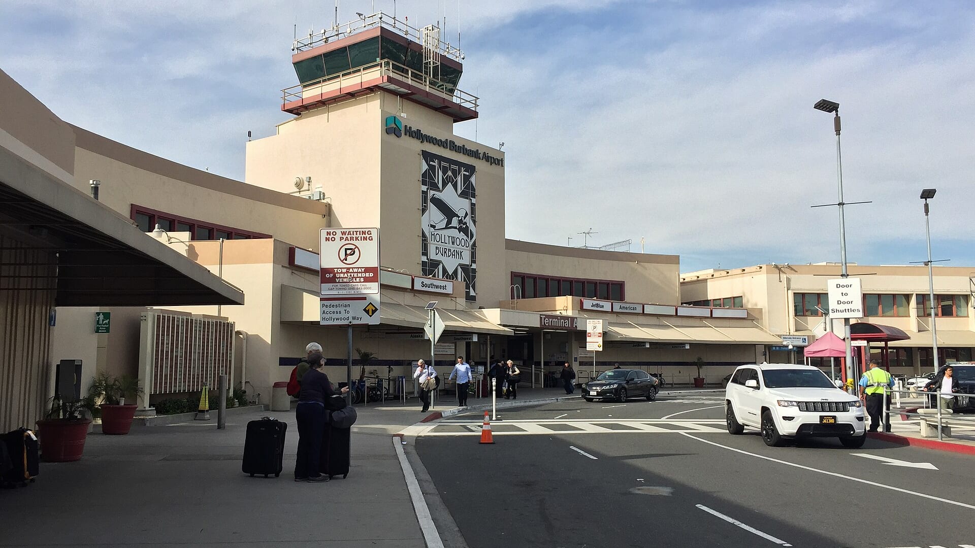 Hollywood Burbank Airport terminal exterior with entrance, people, and vehicles