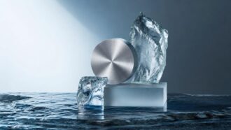 Brushed metal disc and ice blocks on reflective surface