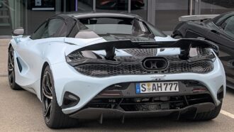 McLaren 750S Spider in light blue parked outside a glass building
