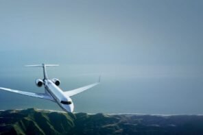 Private jet flying above coastline and mountains