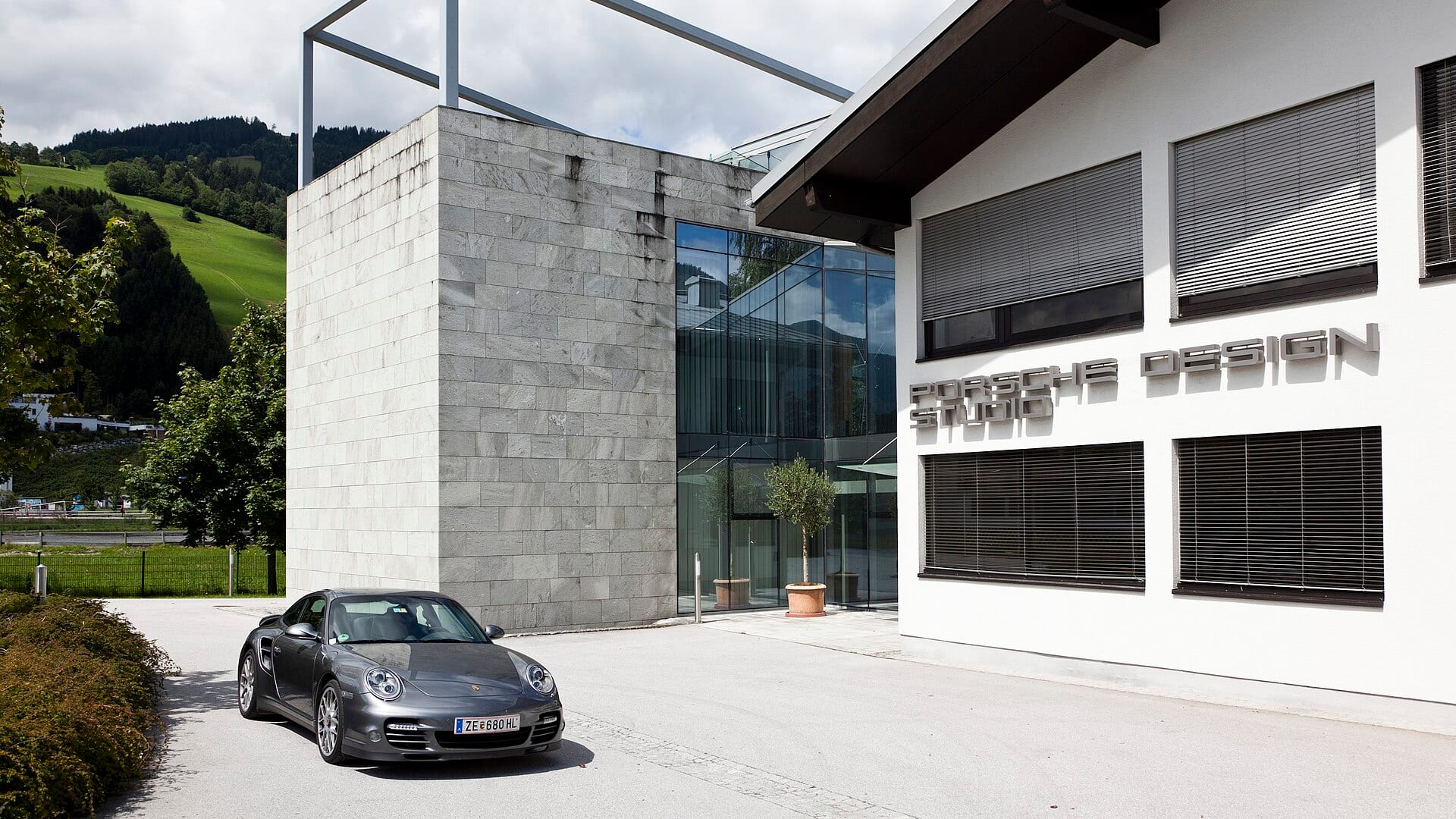 Porsche Design Studio building with a Porsche car parked in front