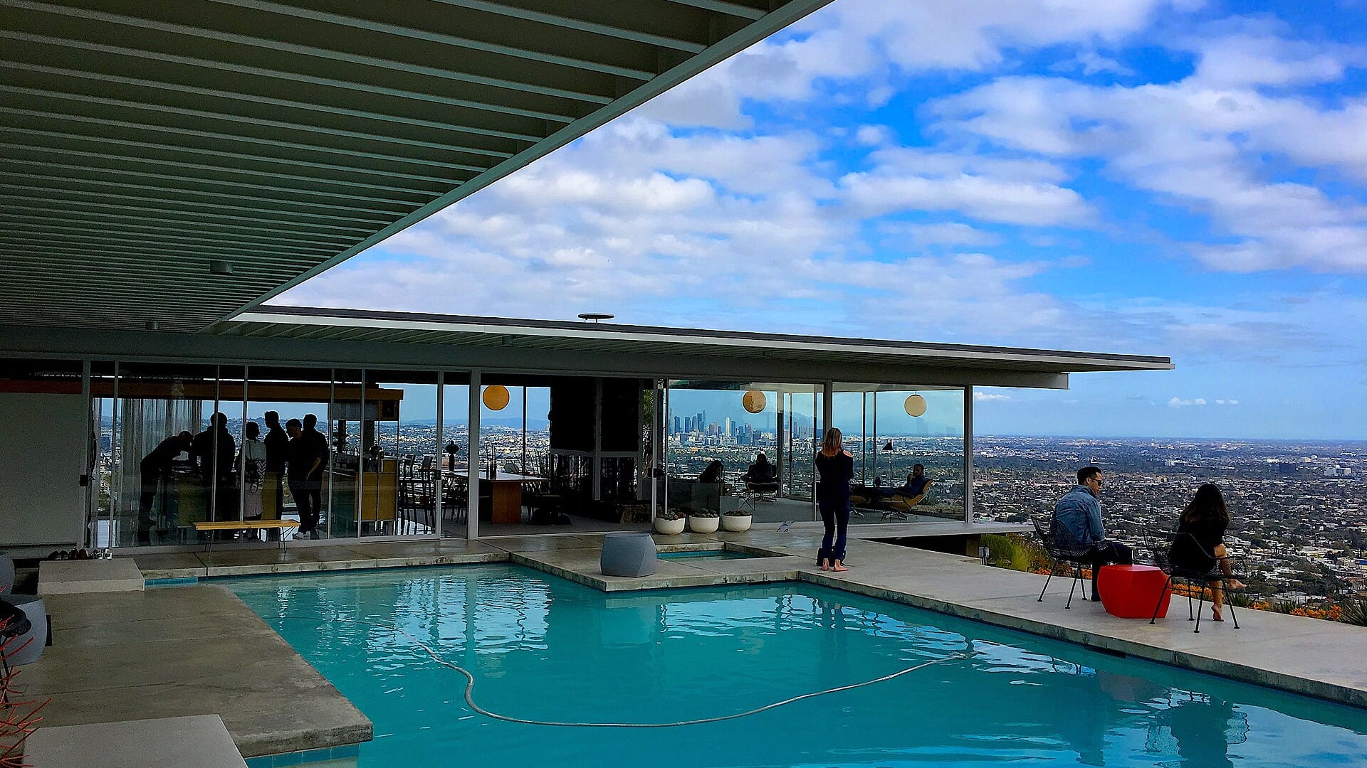 Stahl House pool area with people and panoramic city view