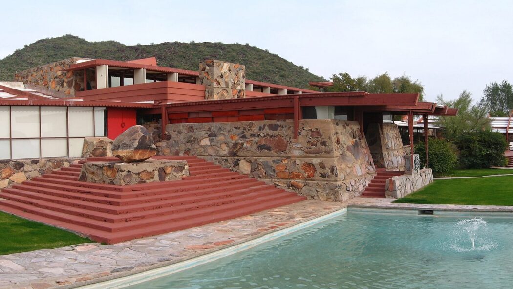 Taliesin West main building with stone walls, red steps, and a pool in Scottsdale